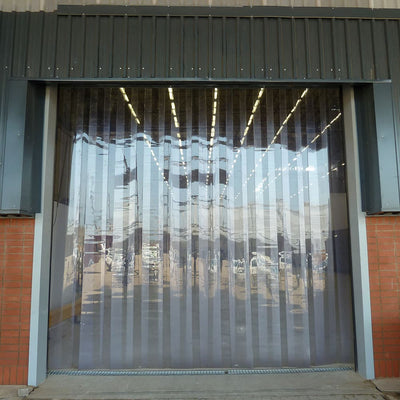 XPS Tech clear PVC strip curtain in a brick doorway — 8 in × 0.080 in × 150 ft nylon-reinforced roll