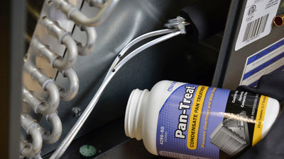 Image of Nu-Calgon 4296-60 Pan-Treat condensate pan tablets bottle next to an air conditioning unit's drain.