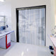 XPS Tech clear PVC strip curtain in a cleanroom doorway — 8 in × 0.080 in × 300 ft nylon-reinforced roll