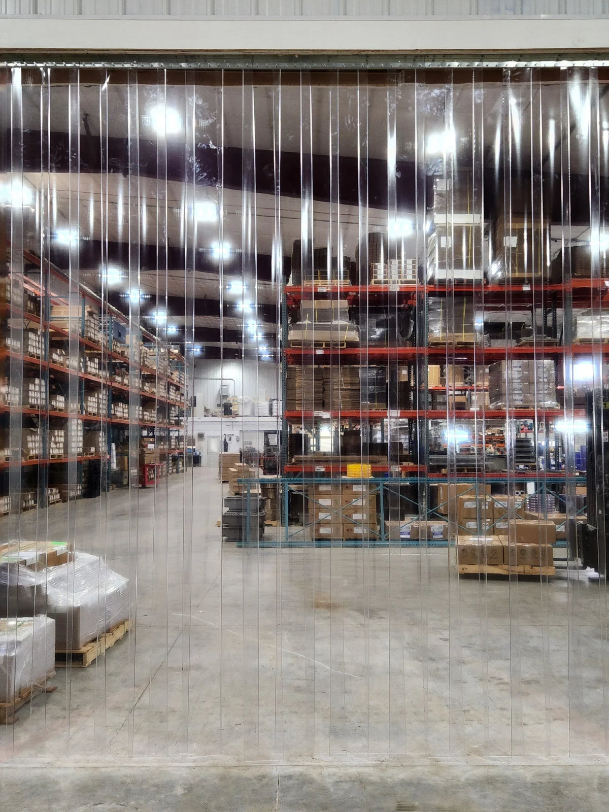 XPS Tech clear nylon-reinforced PVC strip curtain roll, 8 in × 0.080 in × 300 ft, in a warehouse interior