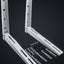 Two white metal wall mounting brackets shown on a dark studio background, with included wall anchors, screws, and washers arranged below them.